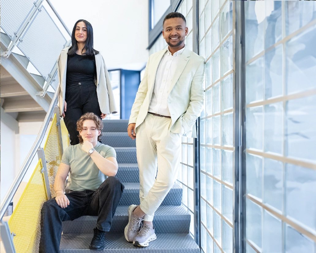 Das Team der Barock Academy Fulda posiert auf einer Industrietreppe mit gelbem Geländer – moderne Business-Fotografie von FourMedia.
